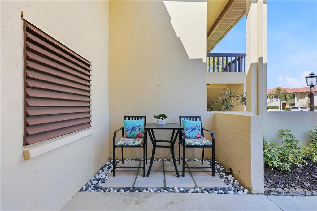 A small patio features two chairs, a table, and a window with brown shutters — 5216 LAKE VILLAGE DRIVE UNIT 71, SARASOTA, FL