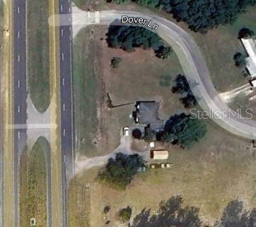 This aerial view shows a house on a lot near a highway and Dover Lane — 2499 N WOODLAND BOULEVARD, DELAND, FL