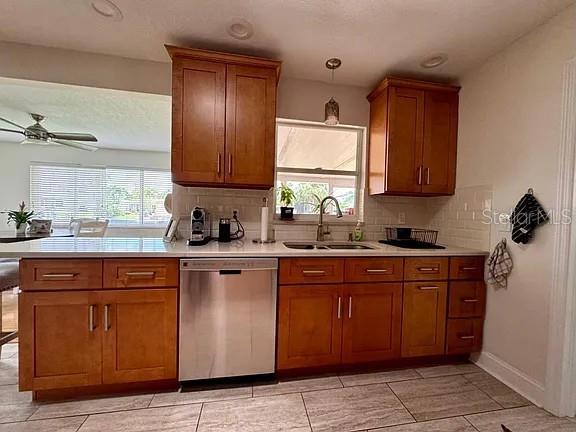 A kitchen features wood cabinets, white countertops, a stainless steel dishwasher, and tile flooring — 4052 14TH WAY NE, ST PETERSBURG, FL
