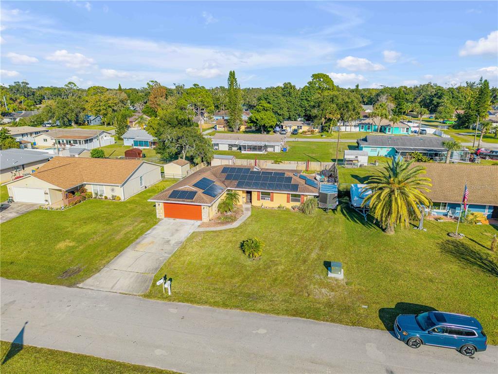 An aerial view of a single-story house with solar panels and a large front yard — 2425 TRAVELERS PALM DRIVE, EDGEWATER, FL