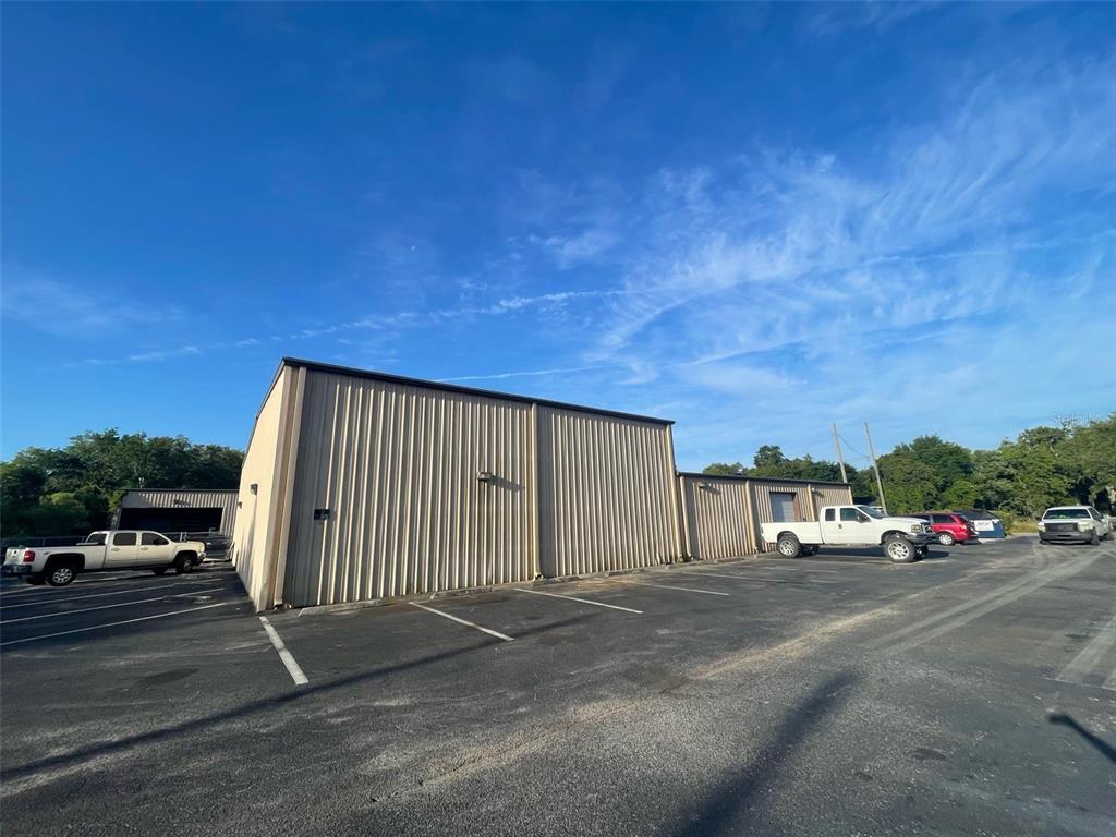 An exterior view of a metal warehouse building with a paved parking lot — 195 WENDELL AVENUE UNIT A, GROVELAND, FL