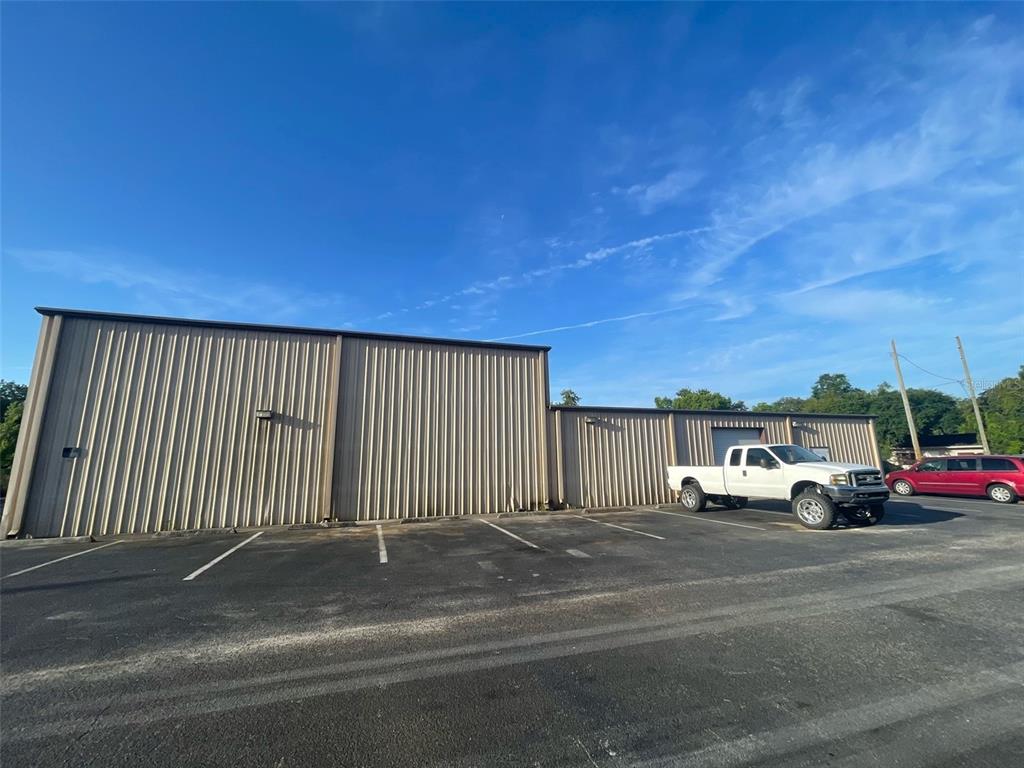 A tan metal industrial building with a parking lot and a white pickup truck — 195 WENDELL AVENUE UNIT A, GROVELAND, FL