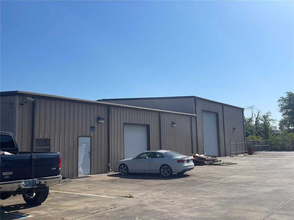 A metal-sided commercial building features two roll-up doors, a pedestrian door, and a parking lot — 195 WENDELL AVENUE UNIT A, GROVELAND, FL