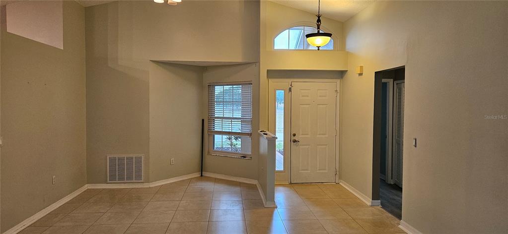 An entryway with tile flooring, a white front door, and a vaulted ceiling — 3186 BENTLEY DRIVE, PALM HARBOR, FL