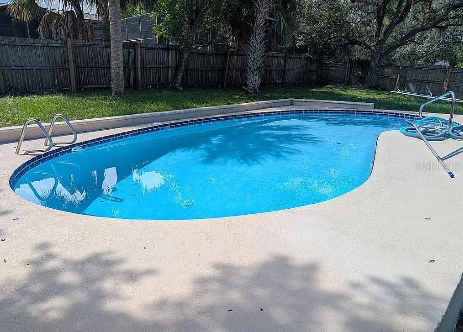 An outdoor swimming pool with a concrete deck and a wooden privacy fence — 6070 ASHLAND DRIVE, SPRING HILL, FL