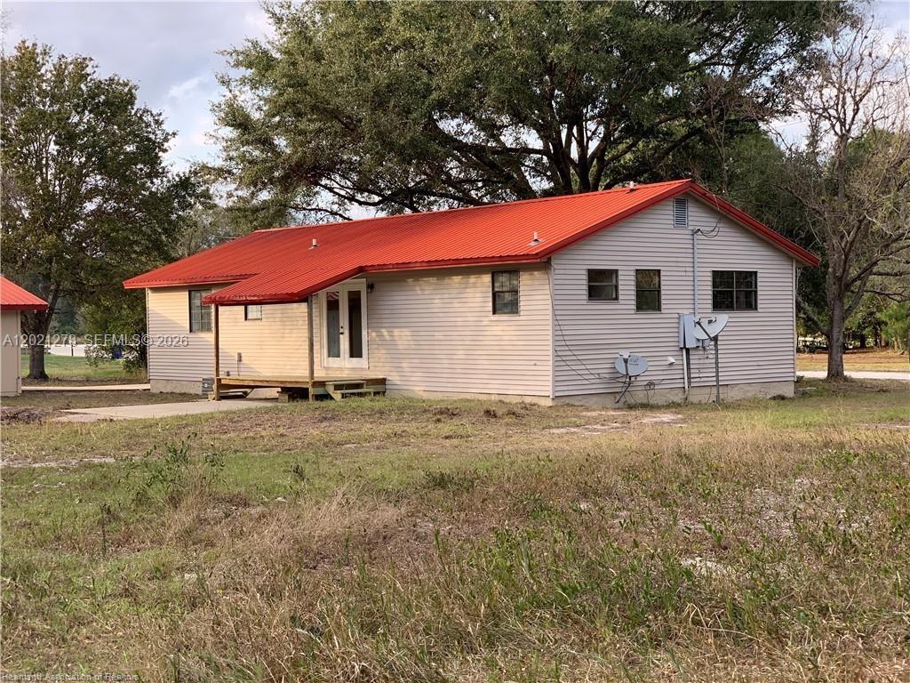 A single-story house with light-colored siding and a bright red metal roof — 2225 N UNICORN # 0, Avon Park FL 33825, AVON PARK, FL