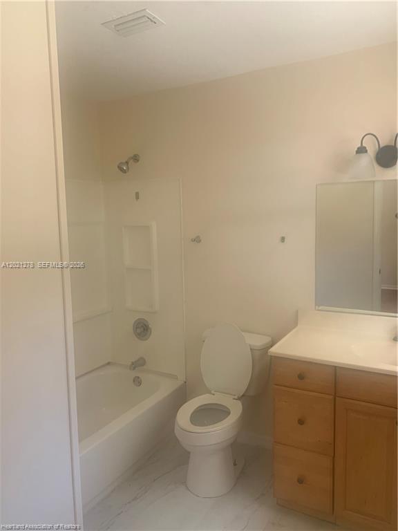 A bathroom features a white bathtub-shower combination, a toilet, and a wooden vanity with mirror — 2225 N UNICORN # 0, Avon Park FL 33825, AVON PARK, FL