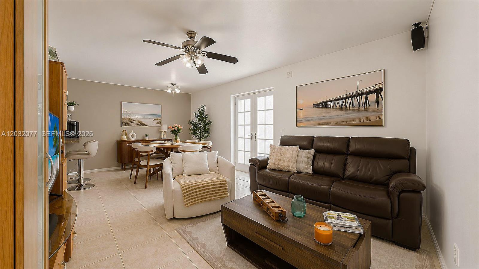 This living and dining area features tile flooring, a brown leather sofa, and French doors — 14 Matador Ln # 27, Davie FL 33324, DAVIE, FL