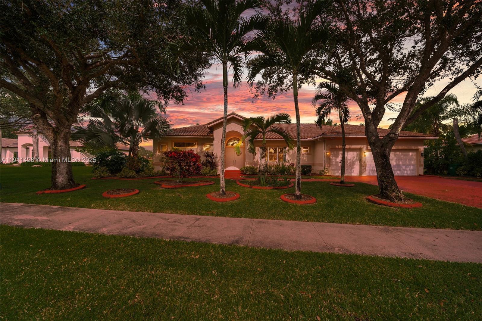 A single-story house with a tiled roof and palm trees stands behind a grassy lawn — 13875 SW 41st St, Davie FL 33330, DAVIE, FL