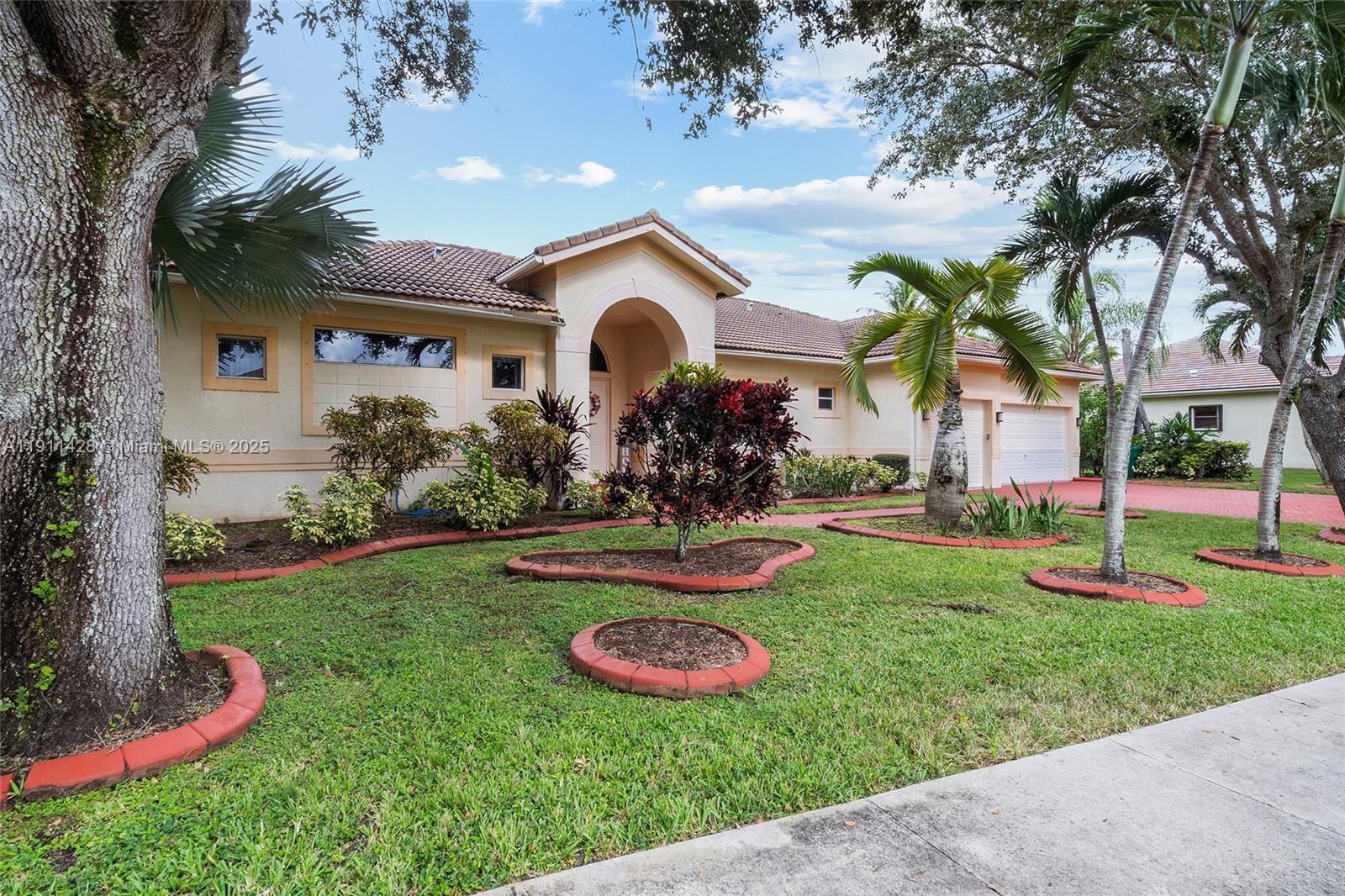 A single-story house with a tiled roof, arched entryway, and landscaped front yard — 13875 SW 41st St, Davie FL 33330, DAVIE, FL