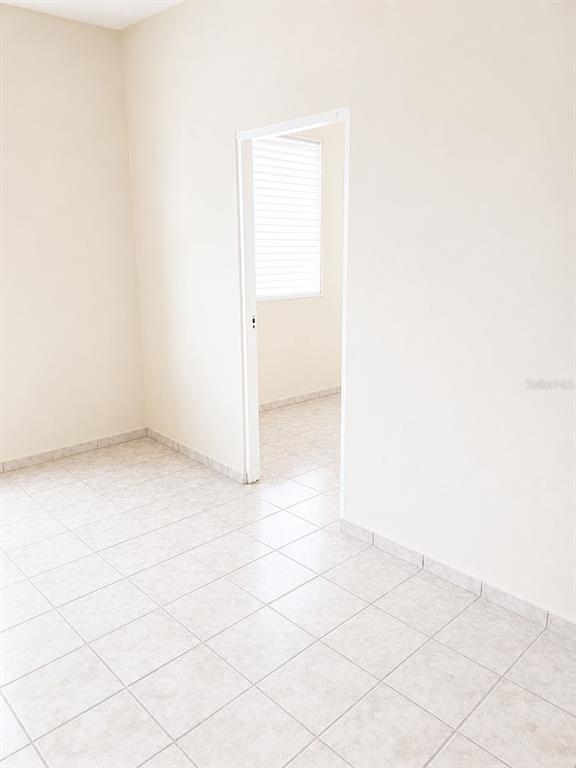 An empty room with light-colored tile flooring and a doorway leading to another space — 54 CALLE DR. VEVE, BAYAMON, PR