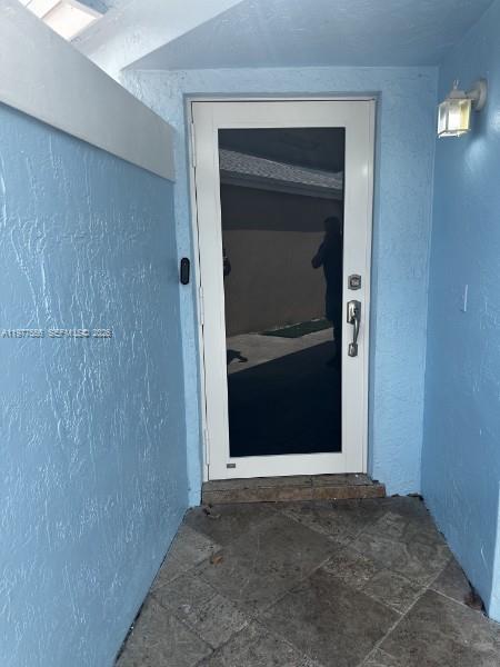 A white storm door with a dark glass panel is set in a light blue entryway — 14952 SW 75th Ter, Miami FL 33193, MIAMI, FL