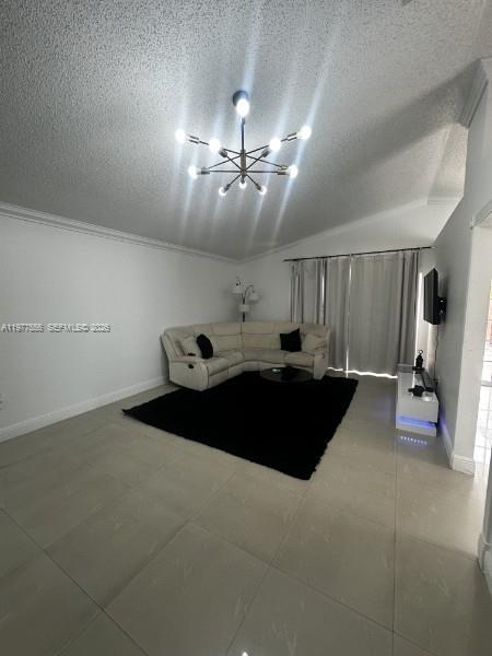 A living room features light tile floors, a white sectional sofa, and a modern chandelier — 14952 SW 75th Ter, Miami FL 33193, MIAMI, FL