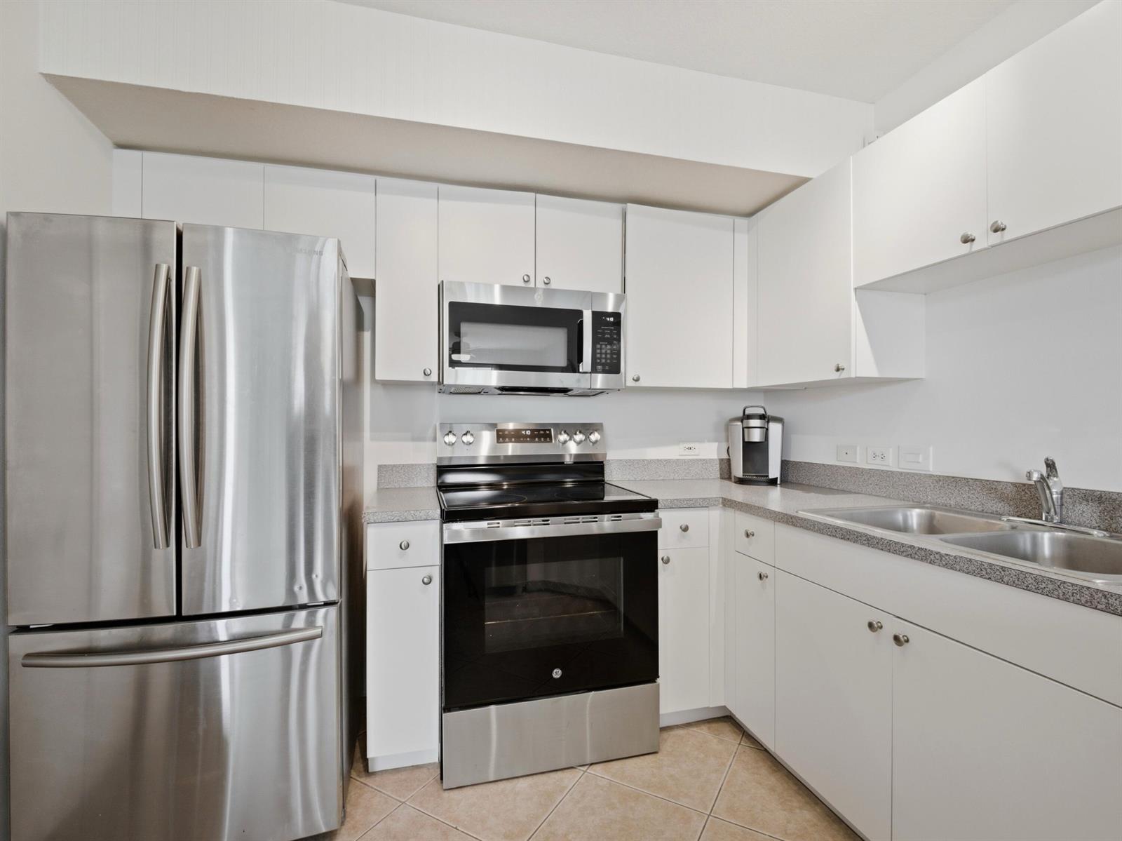 A kitchen featuring white cabinets, stainless steel appliances, and gray granite countertops — 316 Villa Circle, Boynton Beach FL 33435, BOYNTON BEACH, FL