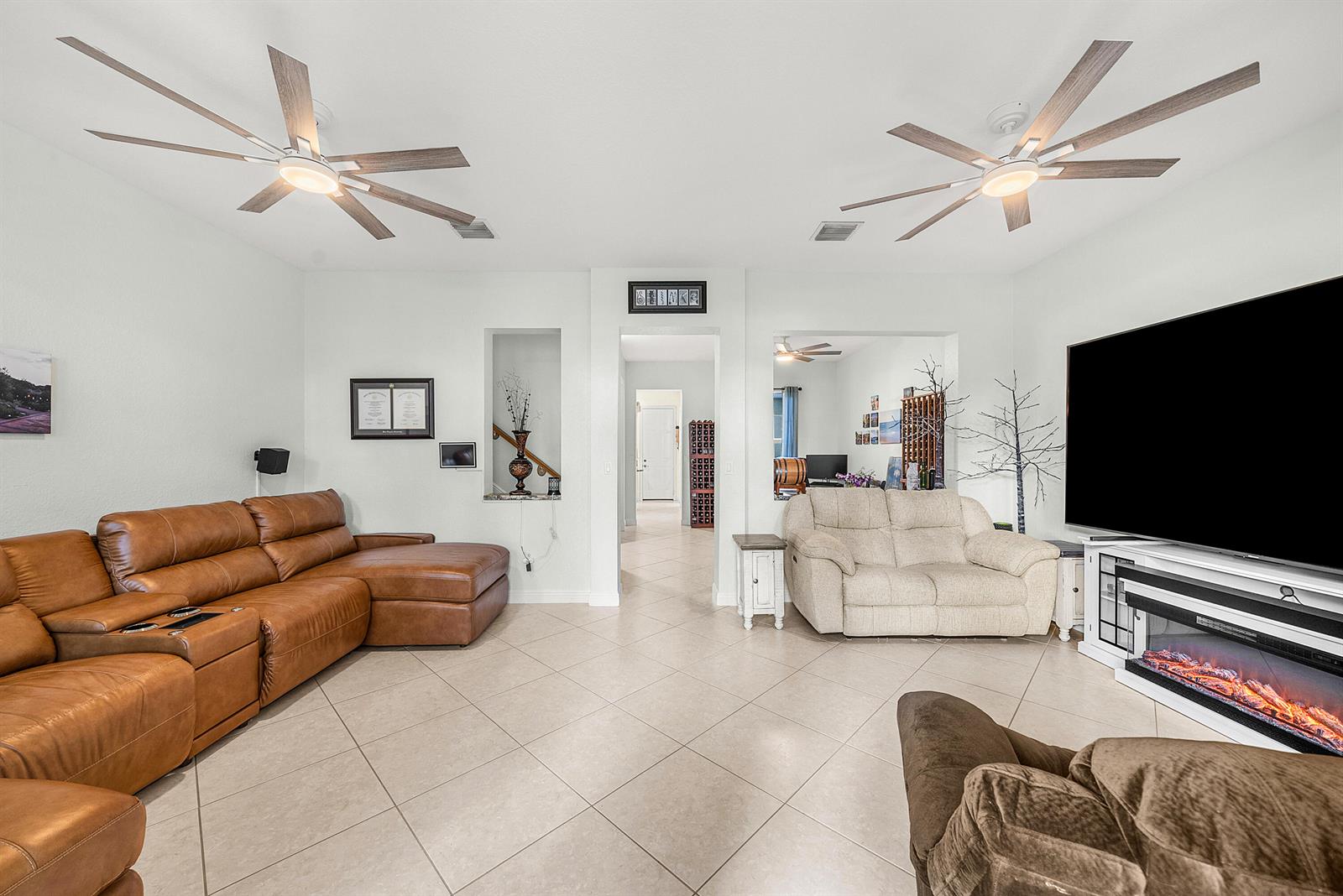 A living room features a large leather sectional, a fireplace, and two ceiling fans — 704 NW 83rd Place, Boca Raton FL 33487, BOCA RATON, FL