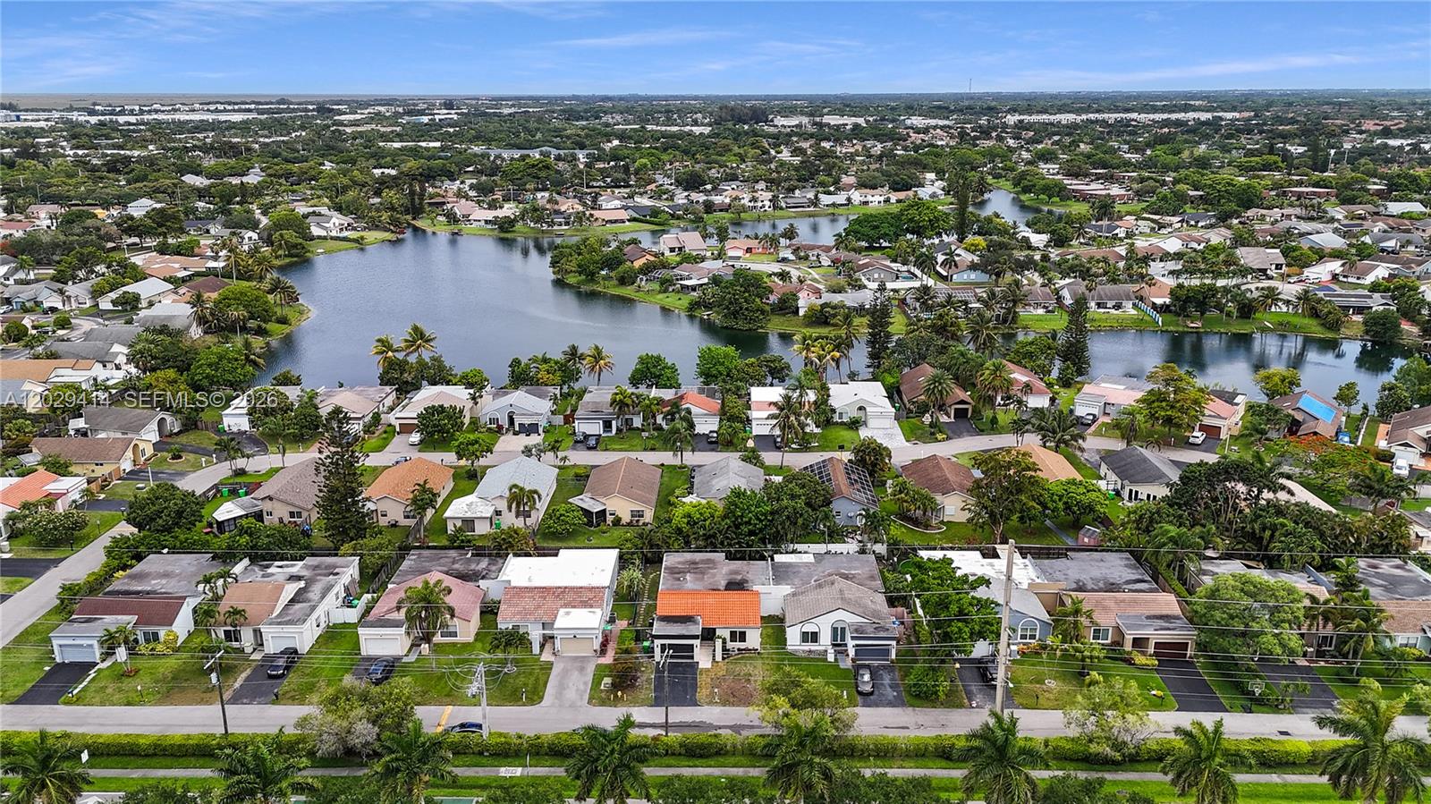 An aerial view shows a suburban neighborhood with houses surrounding a large lake — 9661 NW 44th Ct, Sunrise FL 33351, SUNRISE, FL