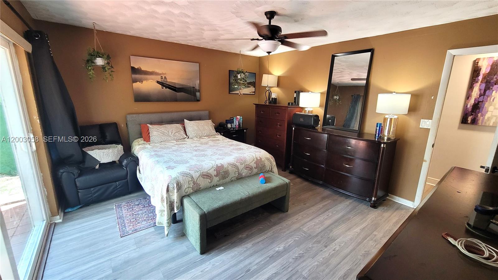 A bedroom features a bed, dark wood furniture, a ceiling fan, and light wood flooring — 22113 SW 97th Ct, Cutler Bay FL 33190, CUTLER BAY, FL