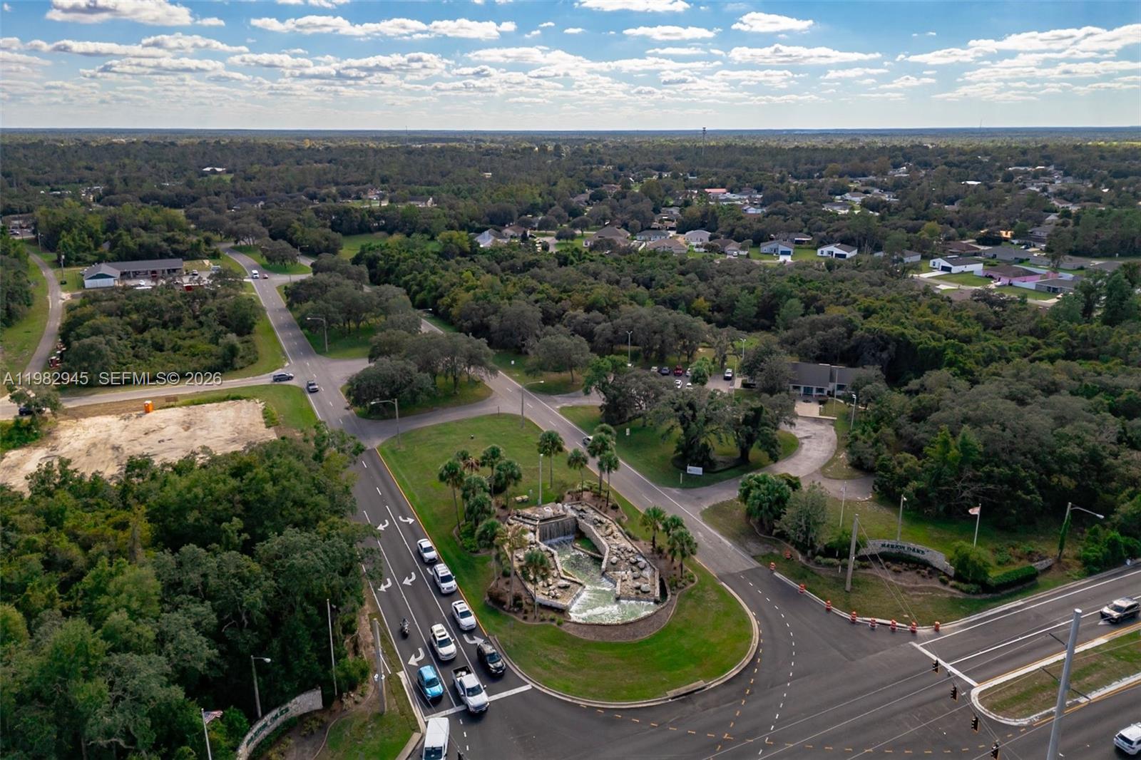 An aerial view shows a landscaped fountain roundabout at a road intersection surrounded by trees — 174 Street, Ocala FL 34473, OCALA, FL