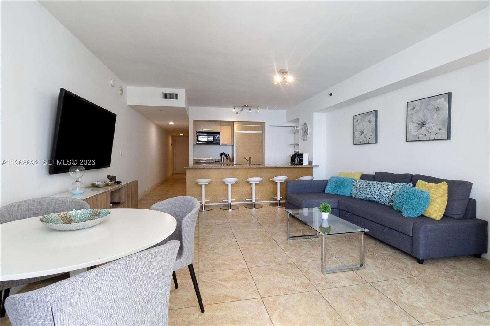 This open-concept living area features a kitchen with a breakfast bar and tile flooring — 1830 S Ocean Dr # 2409, Hallandale Beach FL 33009, HALLANDALE BEACH, FL