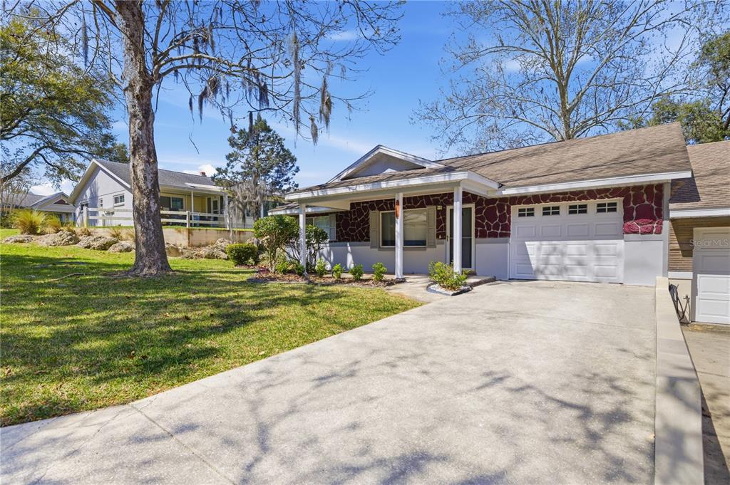 A single-story house with a stone facade, a concrete driveway, and a two-car garage — 8637 SW 97TH LANE ROAD UNIT A, OCALA, FL