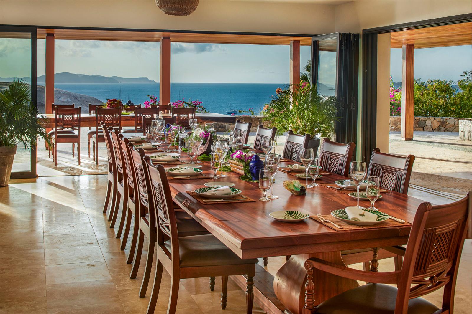 A long wooden dining table sits in an open-air room overlooking the ocean and mountains — 0 Valley Trunk Est-Virgin Gorda, FL