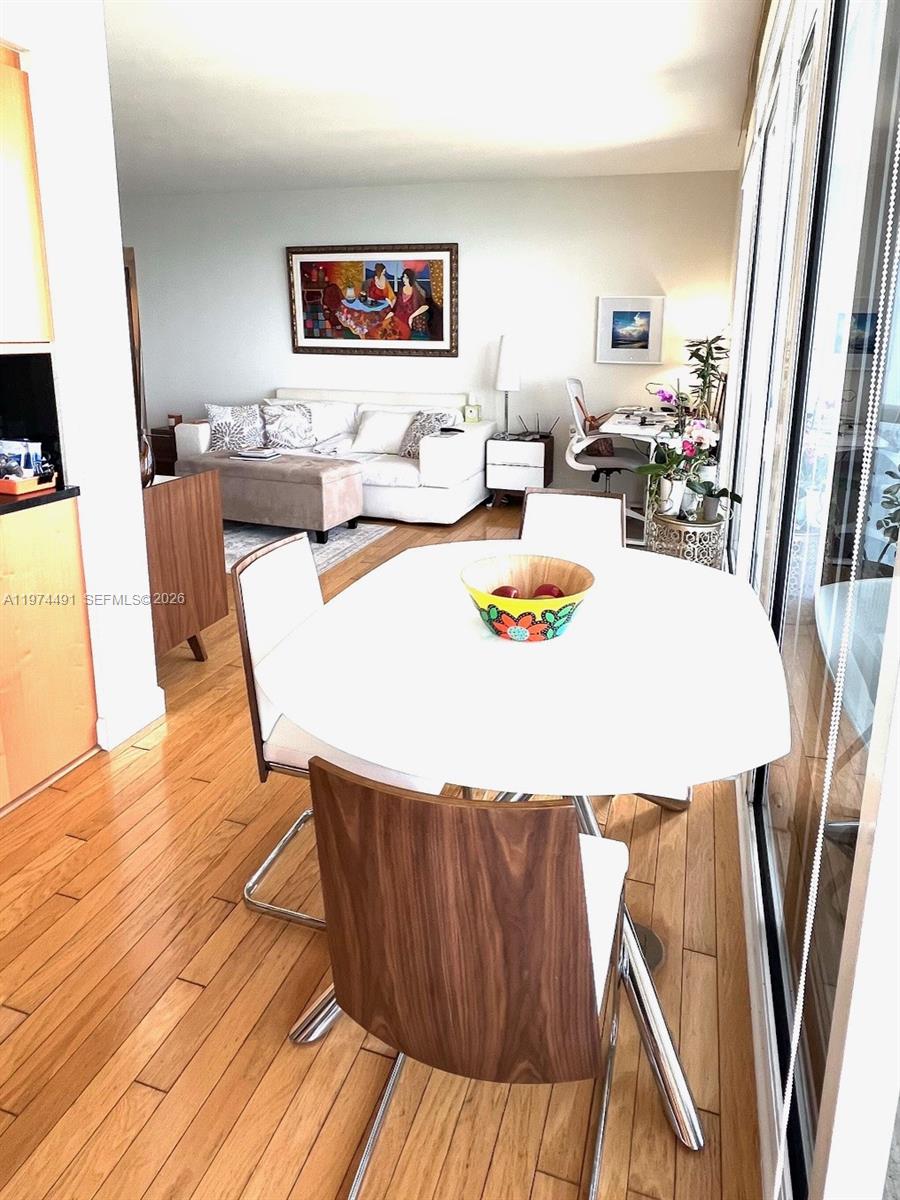 A dining area with a round white table sits in front of a living room — 6365 Collins Ave # 3609, Miami Beach FL 33141, MIAMI BEACH, FL
