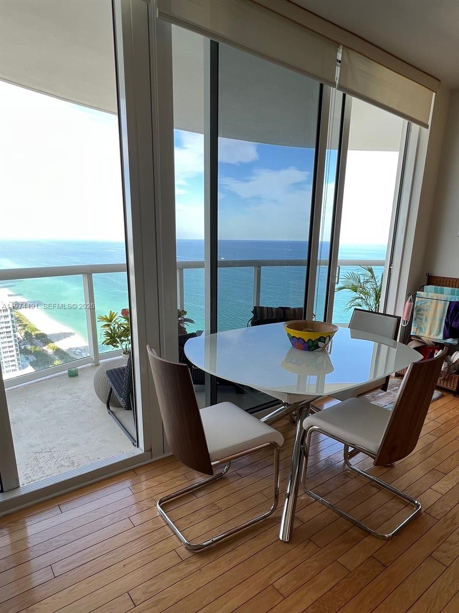 A dining area with a white table and two chairs overlooks the ocean from a balcony — 6365 Collins Ave # 3609, Miami Beach FL 33141, MIAMI BEACH, FL