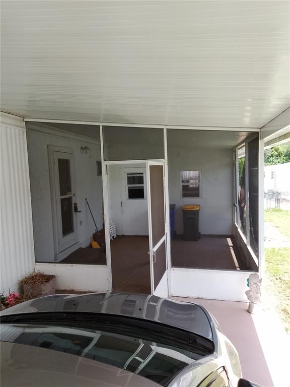 A screened-in porch with a white frame and a door sits under a carport roof — 2904 LAS VEGAS BOULEVARD, SEBRING, FL