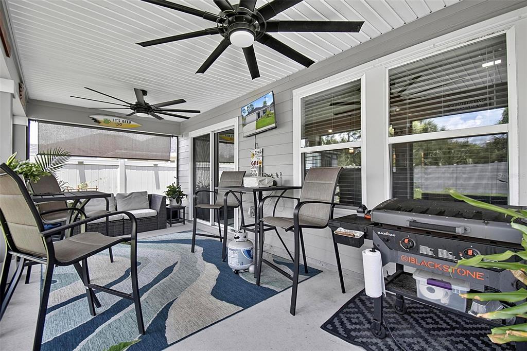 A covered patio features a ceiling fan, outdoor furniture, a television, and a Blackstone grill — 7 SIGNET COURT, FLAGLER BEACH, FL