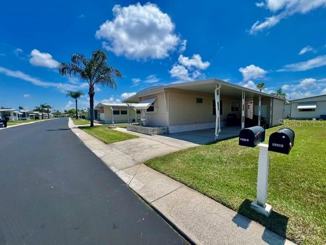 A mobile home with a carport and a pair of mailboxes in the foreground — 10818 FREEDOM DRIVE, PORT RICHEY, FL