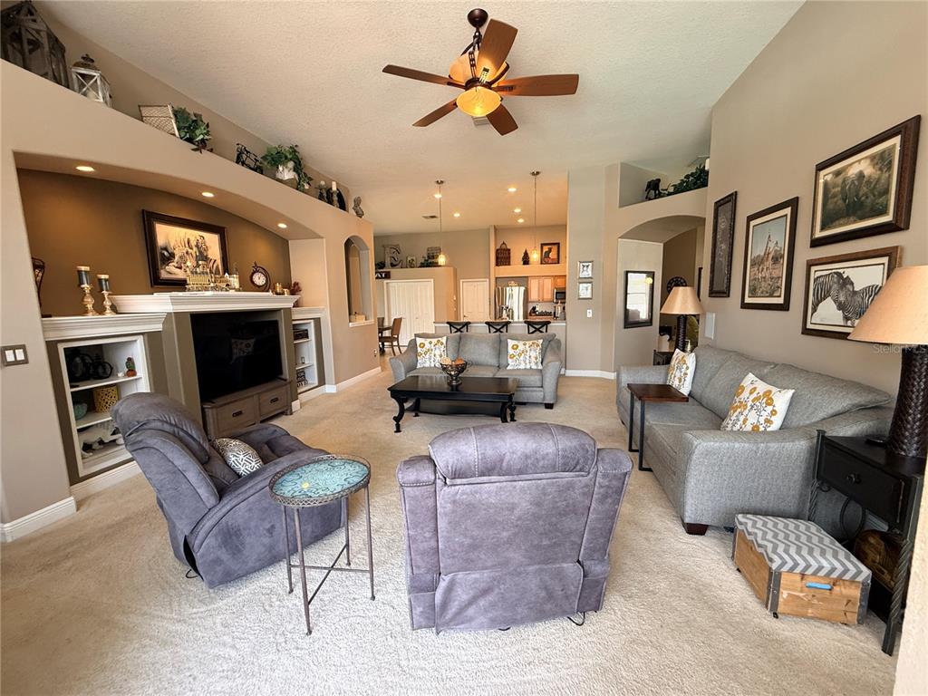 A living room with a large entertainment center, gray furniture, and a ceiling fan — 10236 ESTUARY DRIVE, TAMPA, FL