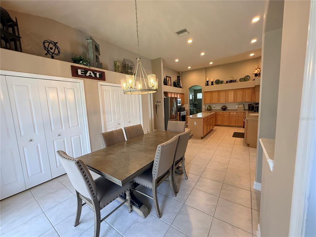 A living room features a grey sofa, two armchairs, a coffee table, and high ceilings — 10236 ESTUARY DRIVE, TAMPA, FL