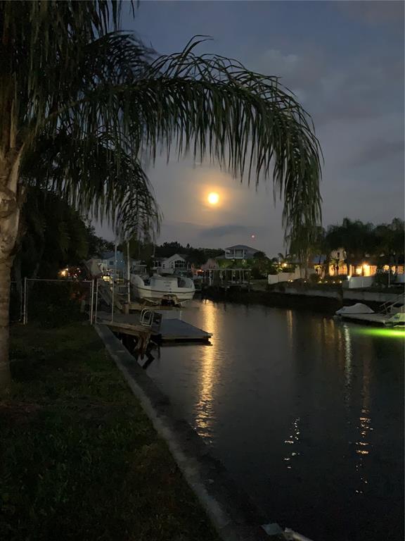 A full moon shines over a canal with boats docked at residential properties at twilight — 7436 YACHTSMAN DRIVE, HUDSON, FL