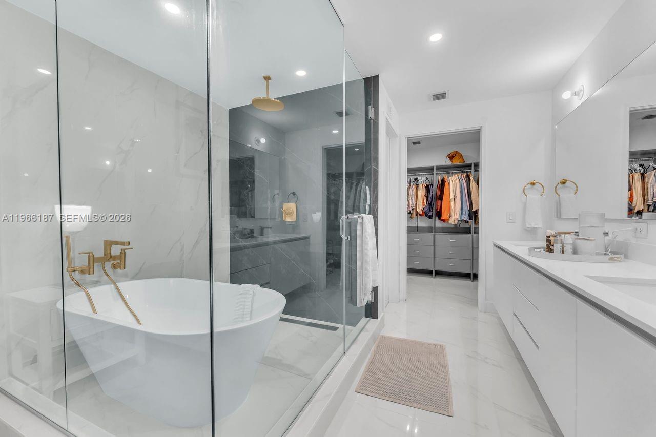 A modern bathroom features a glass-enclosed shower, a freestanding tub, and a double vanity — 700 NE 24th St # 1405, Miami FL 33137, MIAMI, FL