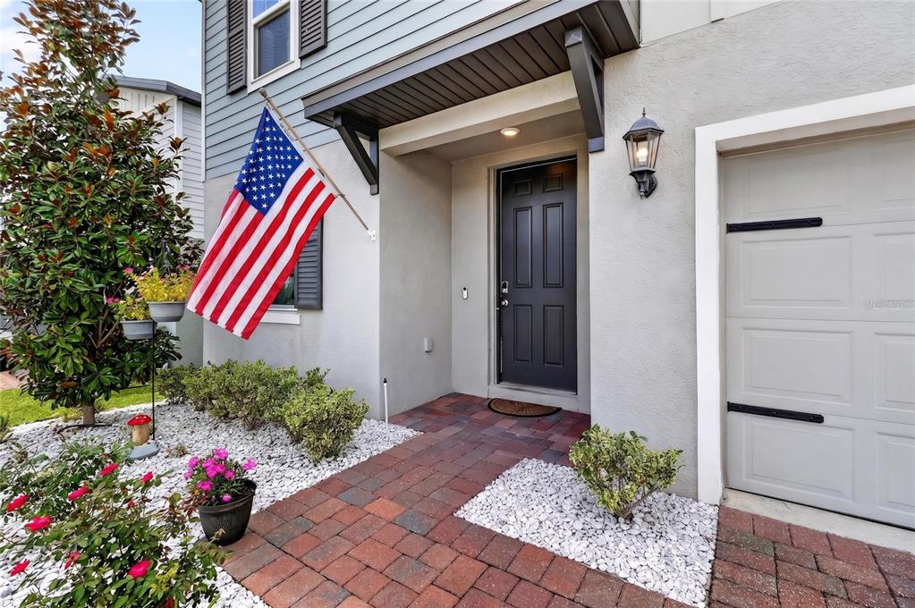 A front entryway features a dark door, a brick walkway, and an American flag — 3310 WEITZEL DRIVE, HAINES CITY, FL