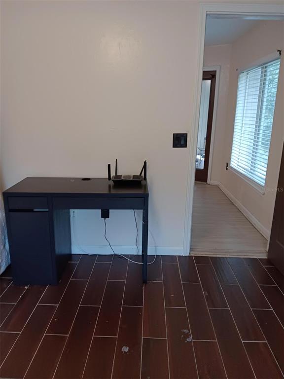 A dark wood desk sits against a white wall on a dark tile floor — 4000 SW 23RD STREET UNIT 4-308, GAINESVILLE, FL