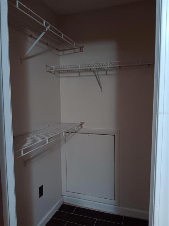 A closet with white wire shelving, dark tile flooring, and a small access panel — 4000 SW 23RD STREET UNIT 4-308, GAINESVILLE, FL