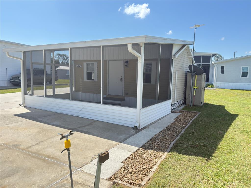 A mobile home features a large screened-in front porch and a concrete driveway — 5073 SHORE LINE DRIVE, POLK CITY, FL