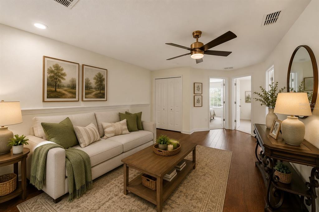 A living room with a beige sofa, wooden coffee table, and dark hardwood flooring — 11927 GREENGATE DRIVE, HUDSON, FL