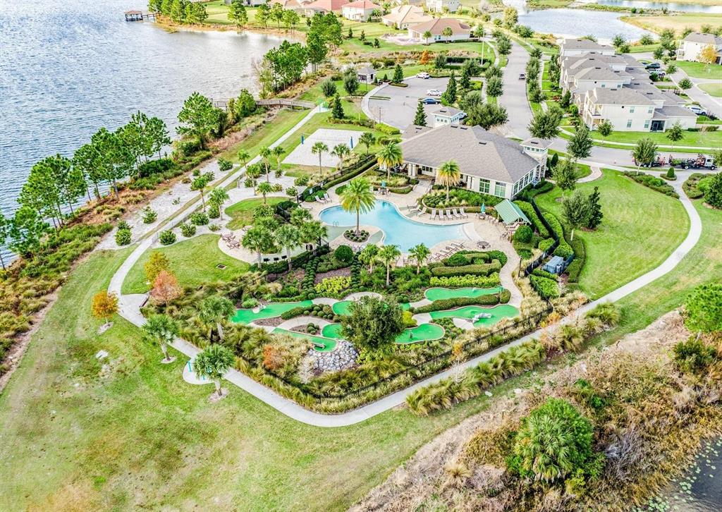 An aerial view shows a community clubhouse with a swimming pool and miniature golf course — 15537 MANGO ISLE STREET, WINTER GARDEN, FL