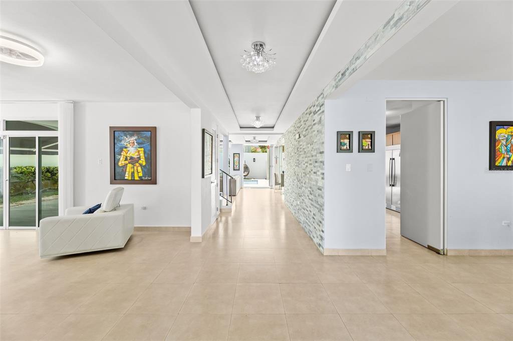 A bright, tiled hallway leads from a living area toward an outdoor patio and pool — JASPER ST. TREASURE POINT UNIT 50, VEGA ALTA, PR