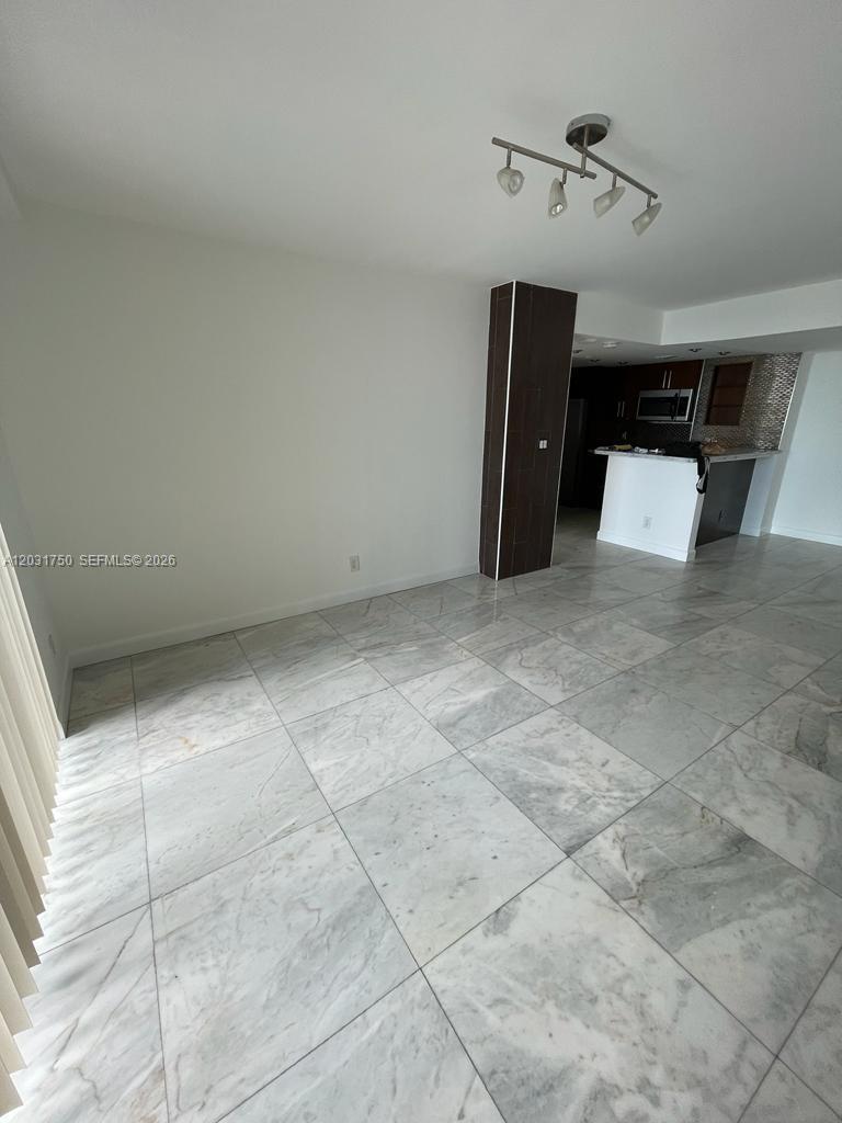 A living area with white marble floors and a dark tiled pillar near the kitchen — 770 Claughton Island Dr # 1504, Miami FL 33131, MIAMI, FL