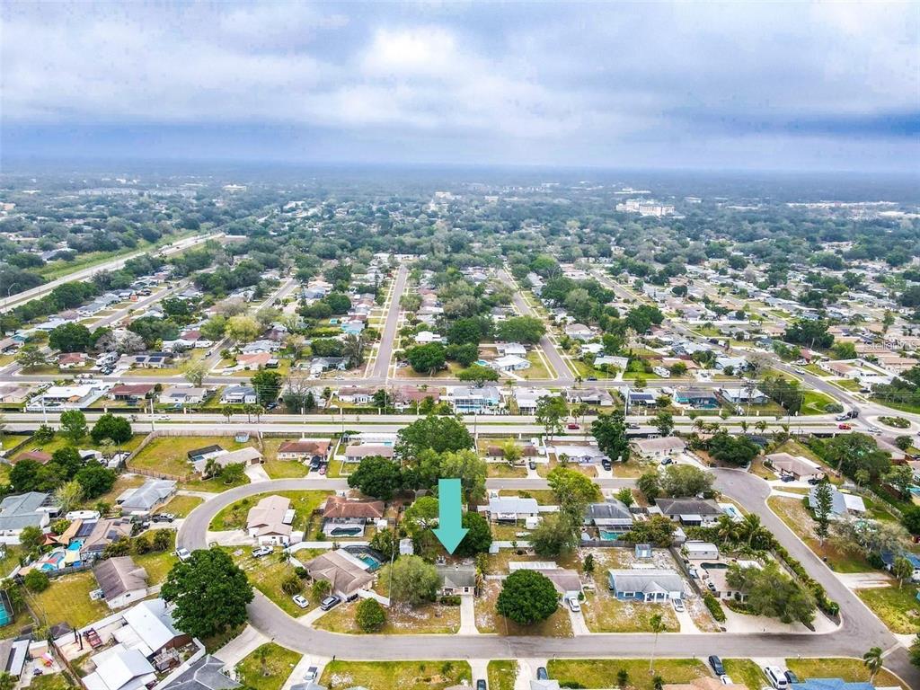 An aerial view shows a residential neighborhood with a light blue arrow pointing to a house — 3314 ISLAND DATE CIRCLE, SARASOTA, FL