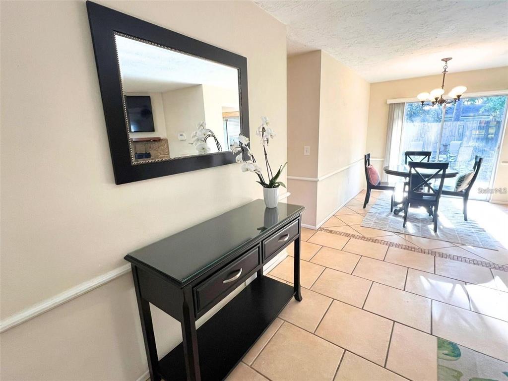 A black console table with a mirror sits in a foyer near a dining area — 3314 ISLAND DATE CIRCLE, SARASOTA, FL
