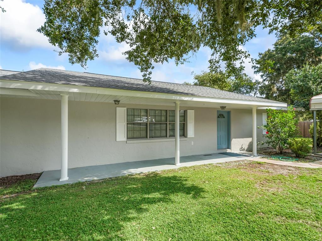 A single-story house with a gray exterior, a covered front porch, and a blue door — 11495 SE 121ST LANE ROAD, BELLEVIEW, FL