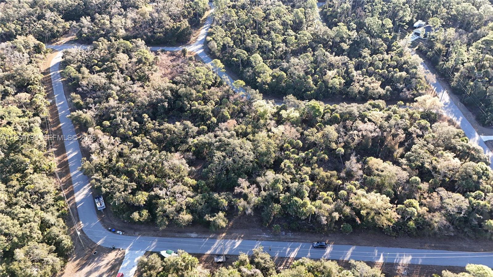 An aerial view shows a wooded lot bordered by paved roads — 0 BACKERT RD, North Port FL 34291, NORTH PORT, FL