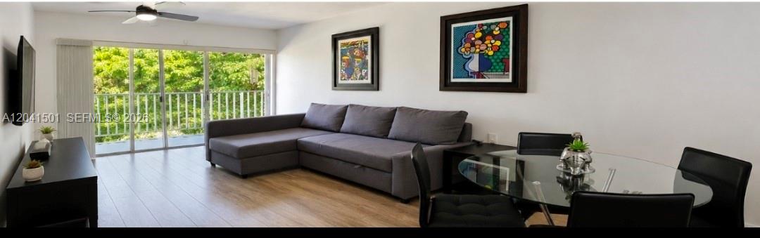 A living room with a gray sectional sofa, glass dining table, and sliding balcony doors — 9611 SW 77th Ave # 305A, Miami FL 33156, MIAMI, FL