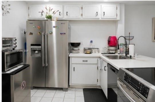 A kitchen with white cabinets, stainless steel appliances, and a tiled floor — 9611 SW 77th Ave # 305A, Miami FL 33156, MIAMI, FL