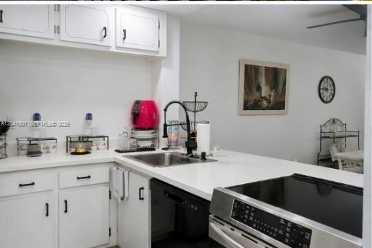 A kitchen features white cabinets, a stainless steel stove, and a white countertop with a sink — 9611 SW 77th Ave # 305A, Miami FL 33156, MIAMI, FL