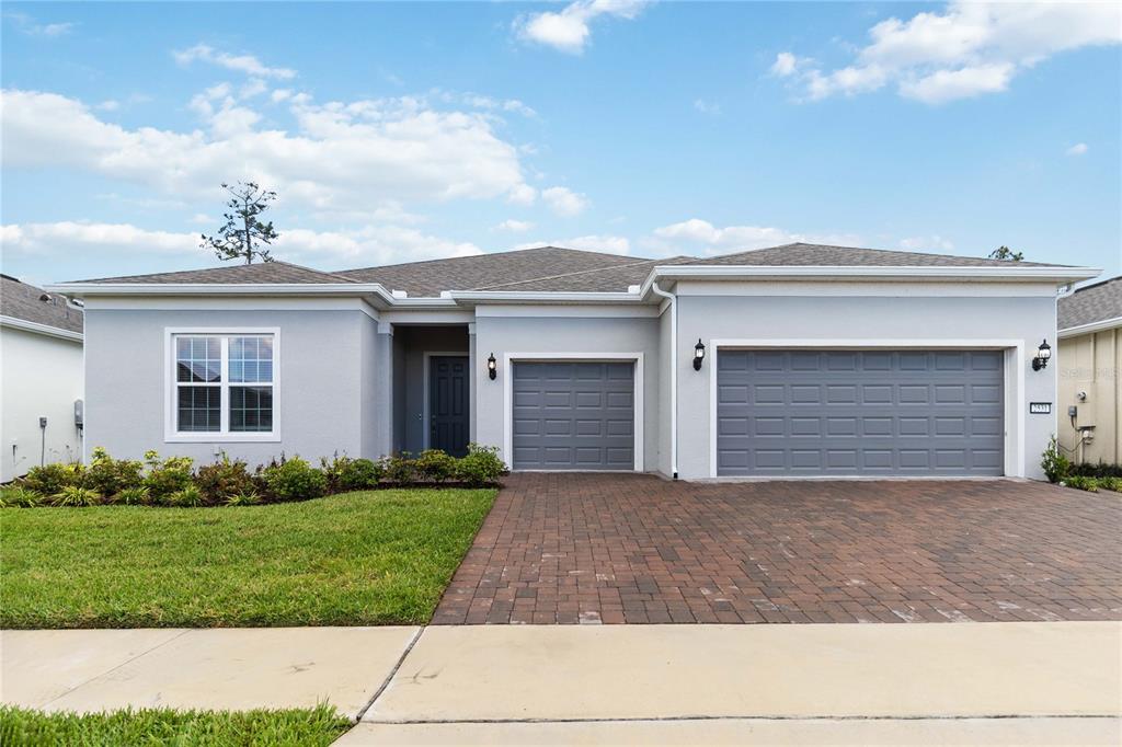 A single-story house with a gray exterior, a brick driveway, and a three-car garage — 2531 PINE PRESERVE COURT, ST CLOUD, FL